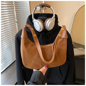 Détail du sac hobo en cuir mat marron avec clous dorés et poignée robuste de qualité