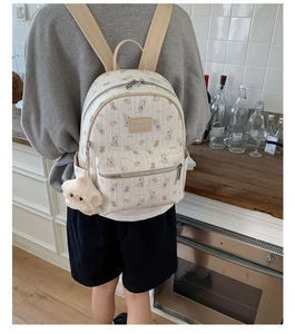 Détail des motifs mignons de lapin et d'ours sur le sac à dos de couleur crème