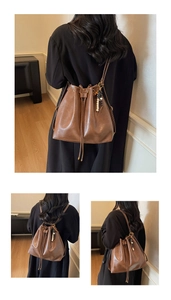 Detail of a brown retro drawstring bucket bag with decorative beaded tassel charms