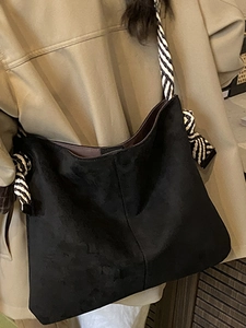 Fashionable black suede tote bag with stylish zebra pattern wide strap on khaki trench coat