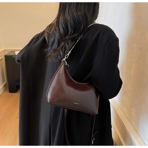 Detail of dark brown oil wax leather shoulder bag with silver chain and NO FILTER print