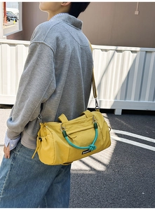 Detail der hellgelben Nylon-Sporttasche mit blauem Knotengriff und seitlicher Kordelzugtasche