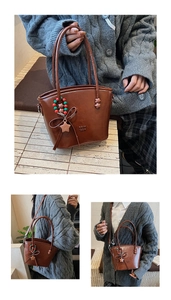 Detail view of dark brown leather bucket bag featuring a star charm and bow decoration