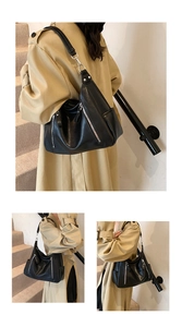 Detail of black PU leather tote bag with vertical zippers and silver metal hardware