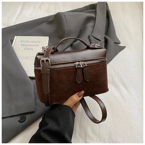 Détail d'un sac boîte marron foncé alliant cuir lisse et daim avec couture zippée