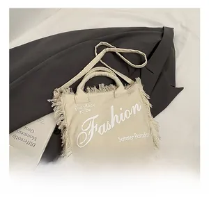 Detail shot of canvas leopard tassel tote with Fashion print and long fringe edges