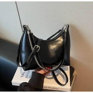 Detail of glossy black patent leather shoulder bag with silver chain and NO FILTER logo