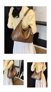 Detail view of large brown hobo bag with dual vertical zippers and adjustable strap
