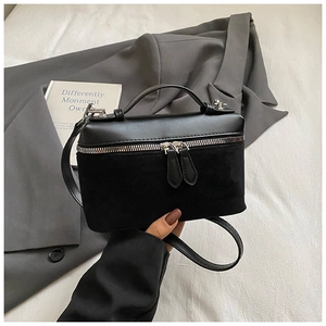 Détail du sac en cuir noir avec double fermeture éclair argentée et poignée en métal