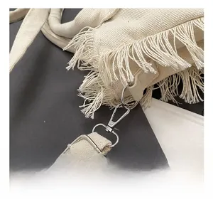 Macro view of high-quality silver metal hook and tassel detail on canvas bag