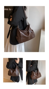 Detail of dark brown leather tote bag with multiple zipper pockets and adjustable straps