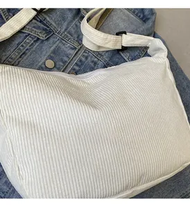 Dettaglio della trama in velluto a coste bianco e tracolla regolabile della borsa
