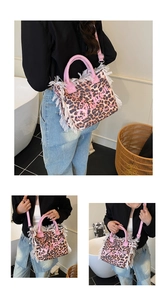 Detail view of pink leopard print tote bag with white fringes and adjustable shoulder strap