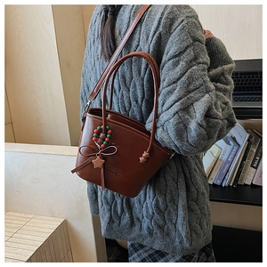 Detailed view of brown PU leather bucket bag with bead charms and logo embossing