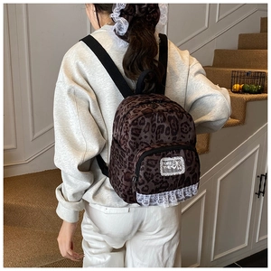 Detailed close-up of leopard print backpack with lace trim and THE FUTURE embroidery