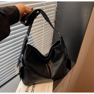 Détail du sac cabas noir en cuir PU avec grandes poches latérales et finitions argentées