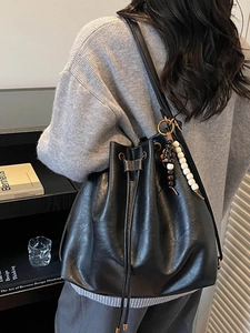 Retro black bucket bag in shiny leather with beaded tassel and drawstring closure