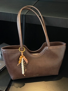 Sac fourre-tout élégant en cuir marron foncé avec bord ondulé et gland en perles