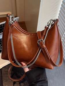 Chic brown leather crescent hobo bag with a modern silver chain strap for women