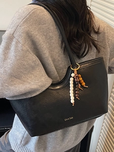 Grand sac cabas noir en cuir minimaliste avec pompon perlé bohème et logo doré