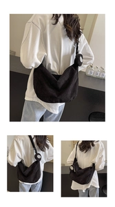 Dettaglio di una grande borsa hobo in velluto a coste nero con ciondolo portamonete abbinato