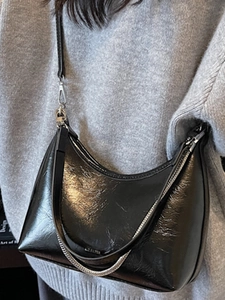 Glossy black hobo shoulder bag with metal chain detail for a stylish urban look