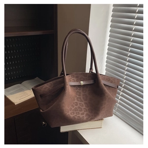 Detail of vintage brown suede tote bag with leopard print and golden buckle