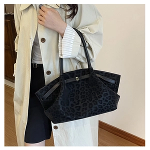 Detail of large leopard print tote bag with metal buckle and slim leather handles
