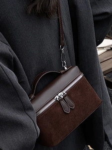 Sac bandoulière marron minimaliste en cuir et daim mélangés, porté par un mannequin