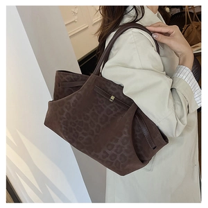 Macro detail of the leopard print suede tote bag featuring signature side buckle strap hardware