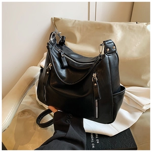Detail view of black PU leather shoulder bag with decorative vertical silver zippers