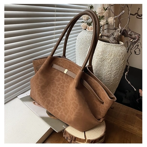 Detail view of large brown leopard print suede tote bag with golden metal buckle and straps