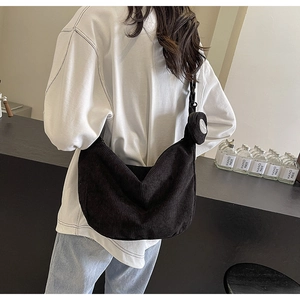 Dettaglio della borsa a tracolla in velluto a coste nero con mini astuccio rotondo rimovibile