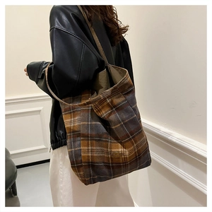 Detail view of the large plaid tote bag showing its texture and capacity on a female model