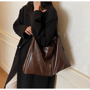 Detailed close-up showing the glossy texture and high-capacity of the brown tote bag