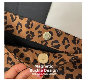 Dettaglio della chiusura magnetica dorata su una borsa leopardata con trama opaca e morbida