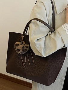 Brown vintage large tote bag with animal embossed pattern and a cute plush bear charm