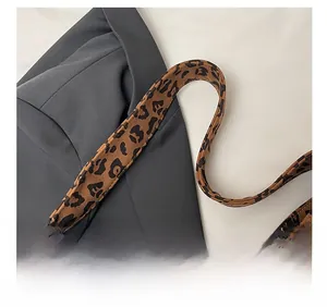 Dettaglio della tracolla larga leopardata con cuciture rinforzate su una grande borsa