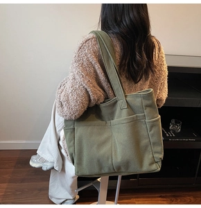 Detail view of olive green corduroy tote bag with side pockets and vertical ribbed texture