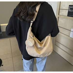 Dettaglio della borsa hobo in velluto a coste beige con mini portamonete e tracolla larga
