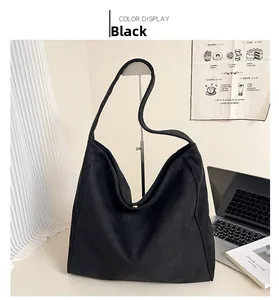 Dettaglio della borsa tote nera opaca con fibbia in metallo magnetico e texture scamosciata