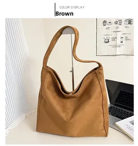 Grande borsa hobo marrone in finta pelle scamosciata esposta su un supporto in metallo moderno