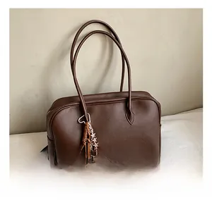 Close-up of brown litchi pattern leather tote bag with a cute checkered puppy charm