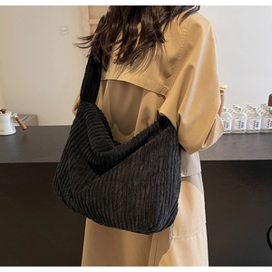 Detail of black corduroy tote bag showing ribbed texture and wide shoulder strap