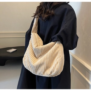 Detail showing the soft corduroy texture and drape of the beige large hobo tote bag