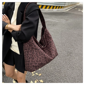 Dettaglio della grande borsa tote in tela leopardata con chiusura a bottone automatico