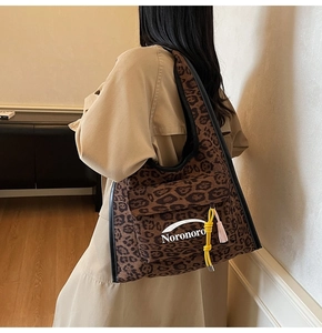 Détail du sac cabas en toile léopard avec charms en corde tressée et logo Noronoro