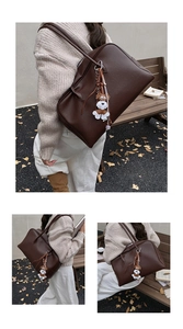 Detailed view of brown litchi grain leather tote bag with a cute puppy bag charm