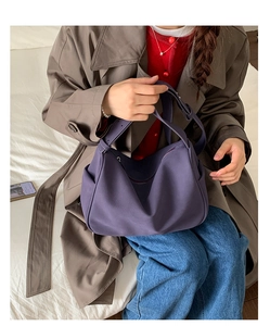 Detail showing purple suede hobo bag textured material and adjustable shoulder strap