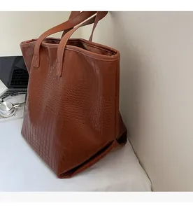 Detail of vintage brown crocodile embossed large tote bag in an office setting